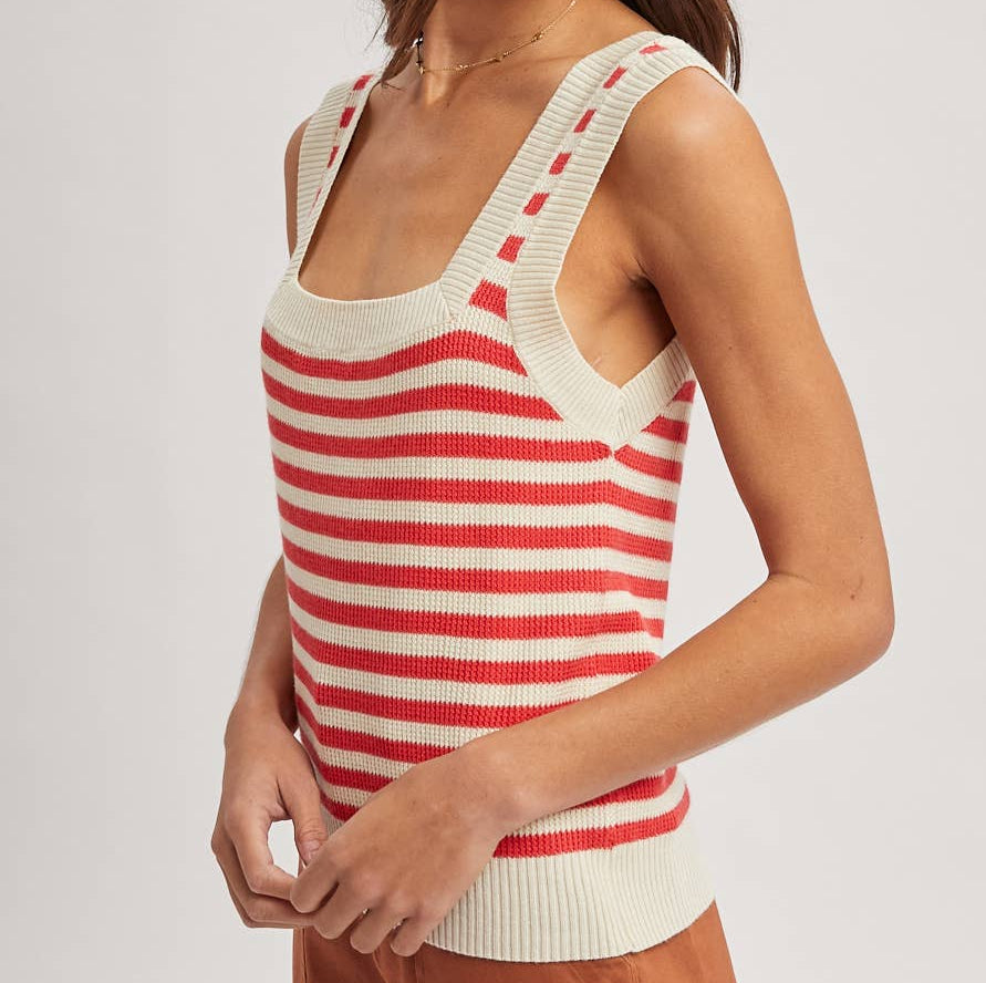 Woman wearing a red and white striped tank top with a plain background