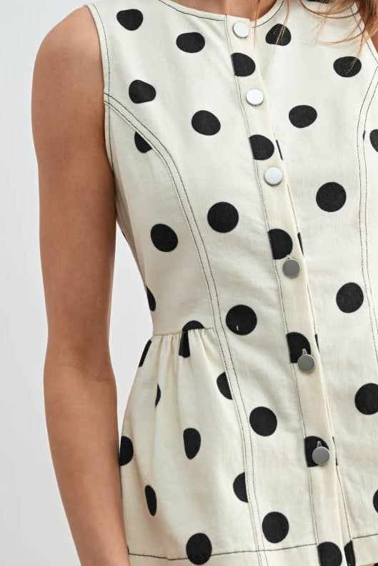 Woman wearing a polka dot shirt with a plain background