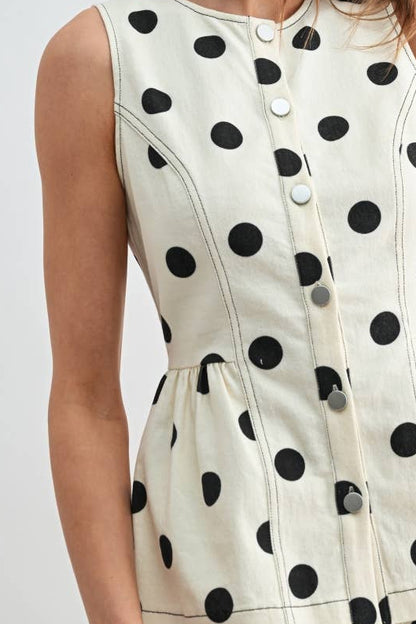 Woman wearing a polka dot shirt with a plain background