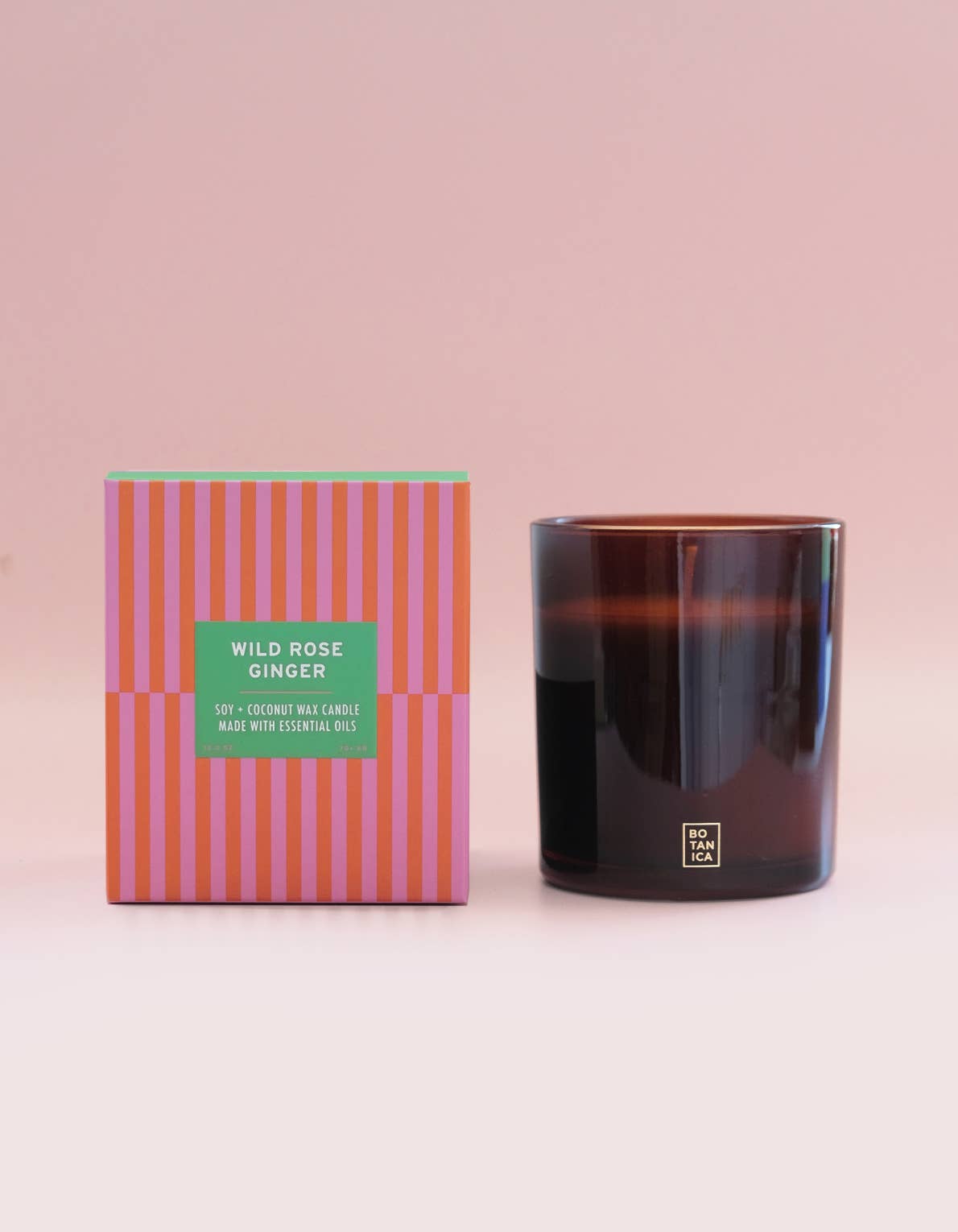 Candle and its packaging with a pink background
