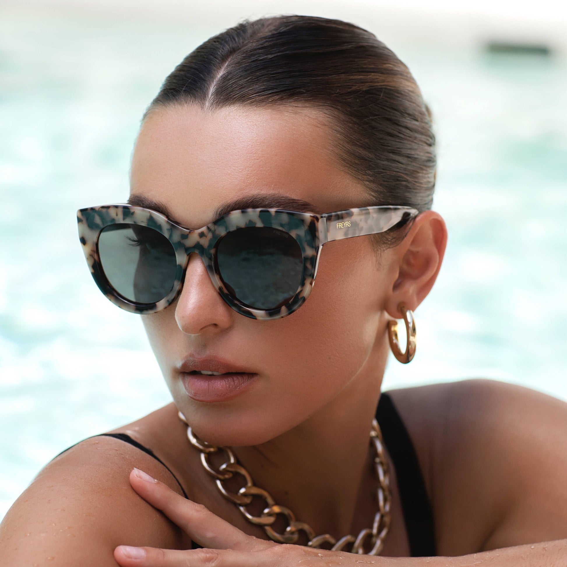Woman wearing leopard print sunglasses with a blurred background