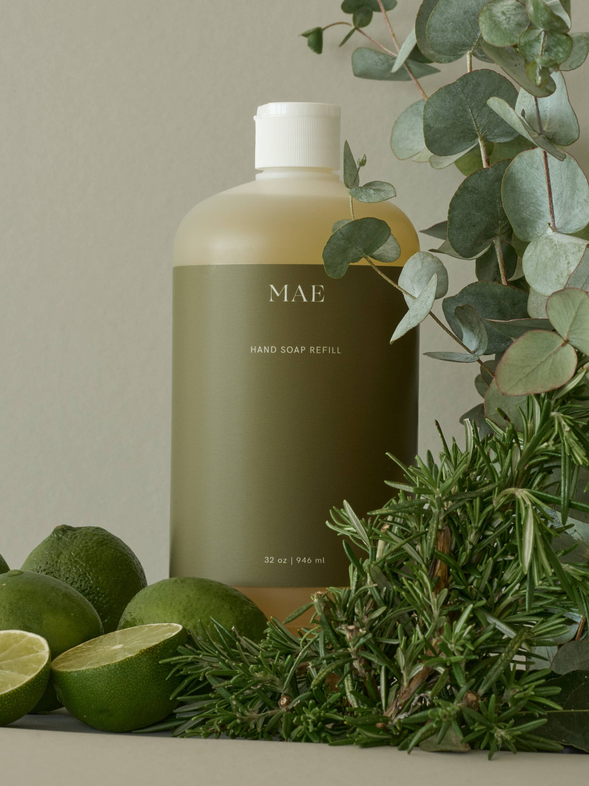 MAE hard soap refill bottle with green limes and herbs on a neutral background