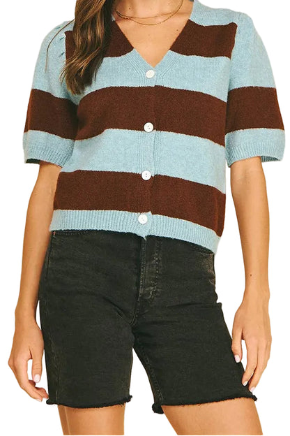 A woman modeling a short-sleeve knit cardigan with horizontal light blue and dark brown stripes, featuring a V-neck and white buttons, paired with black denim shorts against a solid white background.