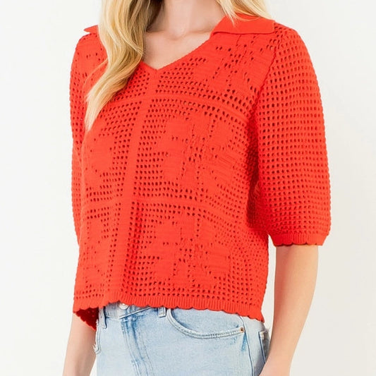 Woman wearing a red crochet top and light blue denim skirt on a white background