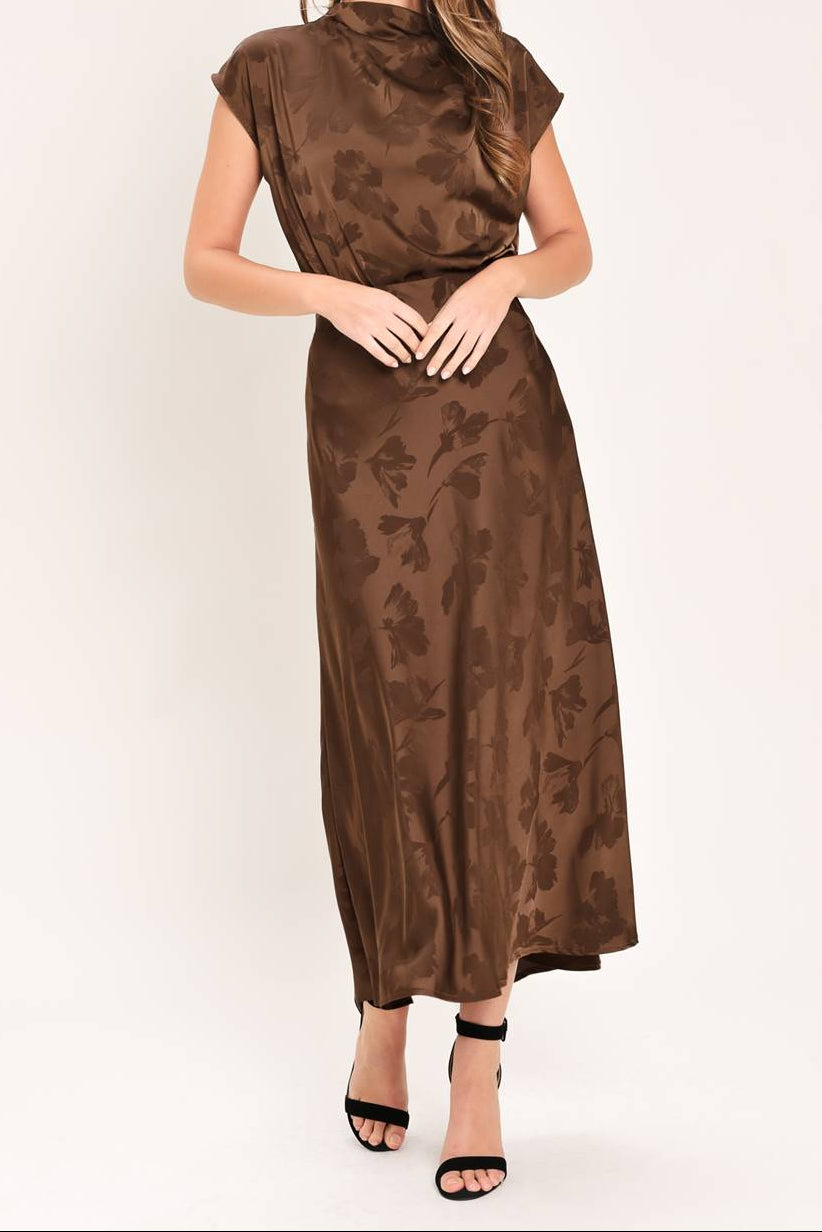 Woman wearing a brown matching skirt set  with a subtle pattern on a white background. 