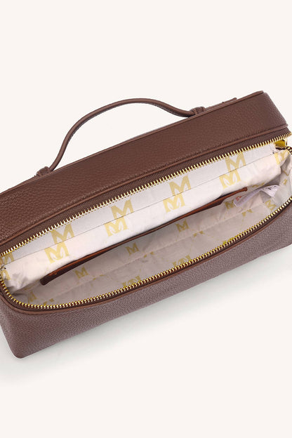 Brown handbag with gold zipper and 'M' logo on a white background