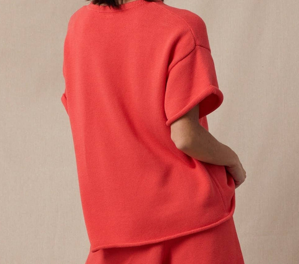 Woman wearing a red outfit with a beige background