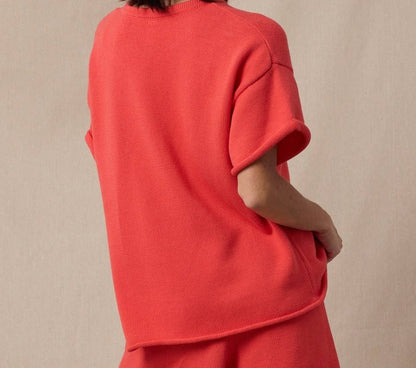 Woman wearing a red outfit with a beige background