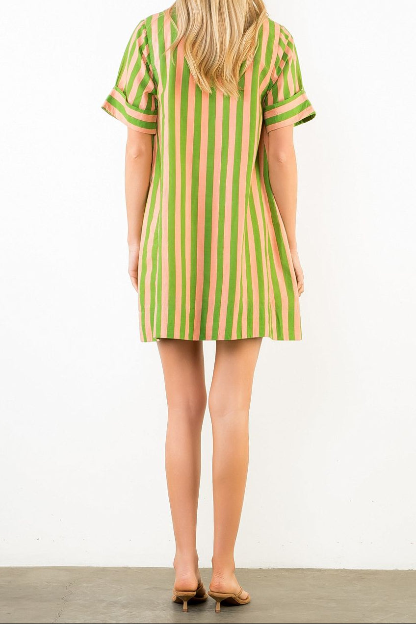 Woman wearing a green and pink striped dress on a white background