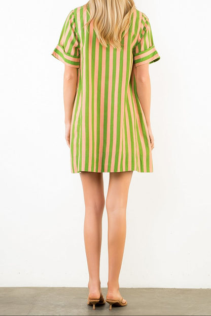 Woman wearing a green and pink striped dress on a white background