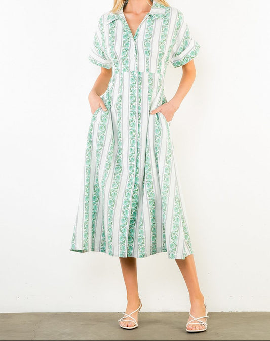 Woman wearing a green and white striped dress against a white background