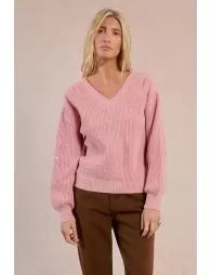 Woman wearing a pink sweater against a plain background